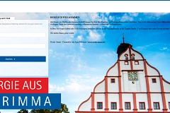 Der Giebel des historischen Rathauses zu Grimma mit klarem Himmel im Hintergrund