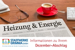 Eine Zeitung mit der Überschrift "Heizung und Energie" liegt auf einem Tisch, dahinter eine rote Kaffeetasse und weitere Zeitungen sowie eine Lesebrille.